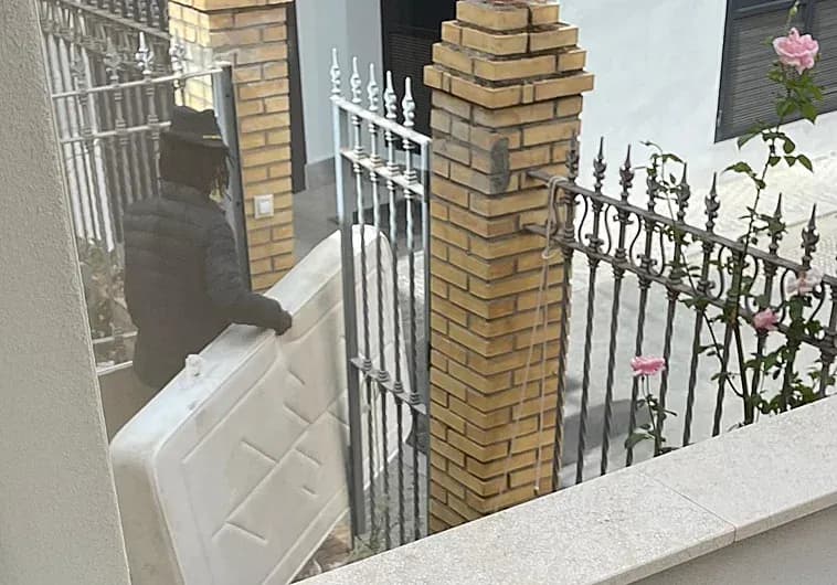 Оккупант заносит матрас в заброшенное здание